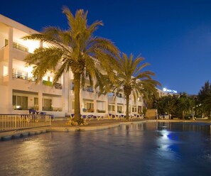Una piscina al aire libre, sombrillas, tumbonas