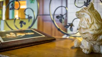 Una mesa de madera con una figurita de gato decorativa y un marco con una fotografía.