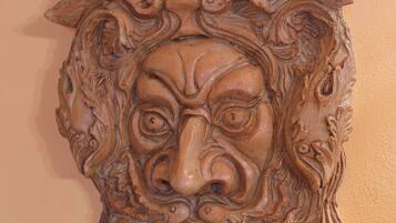 Un masque en bois sculpté, doté de détails complexes et orné d’un trou circulaire au centre.
