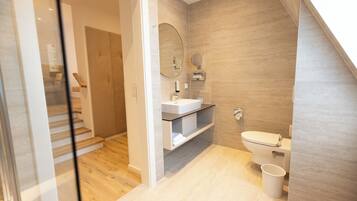 Ein modernes Badezimmer mit Toilette, Waschbecken und Spiegel.