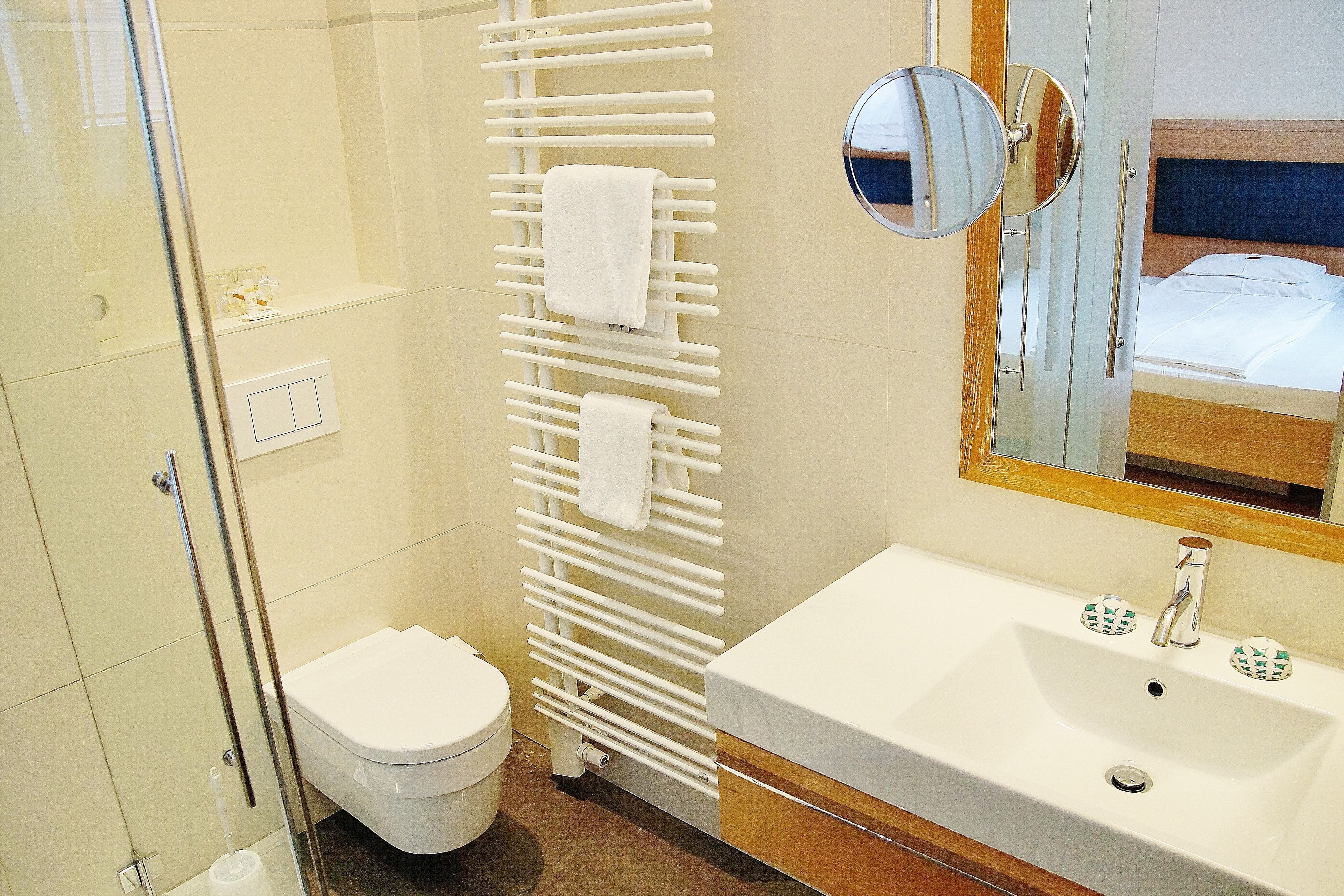 A bathroom with a white sink, a mirror, a towel rack, and a toilet.