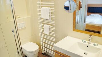 A bathroom with a white sink, a mirror, a towel rack, and a toilet.