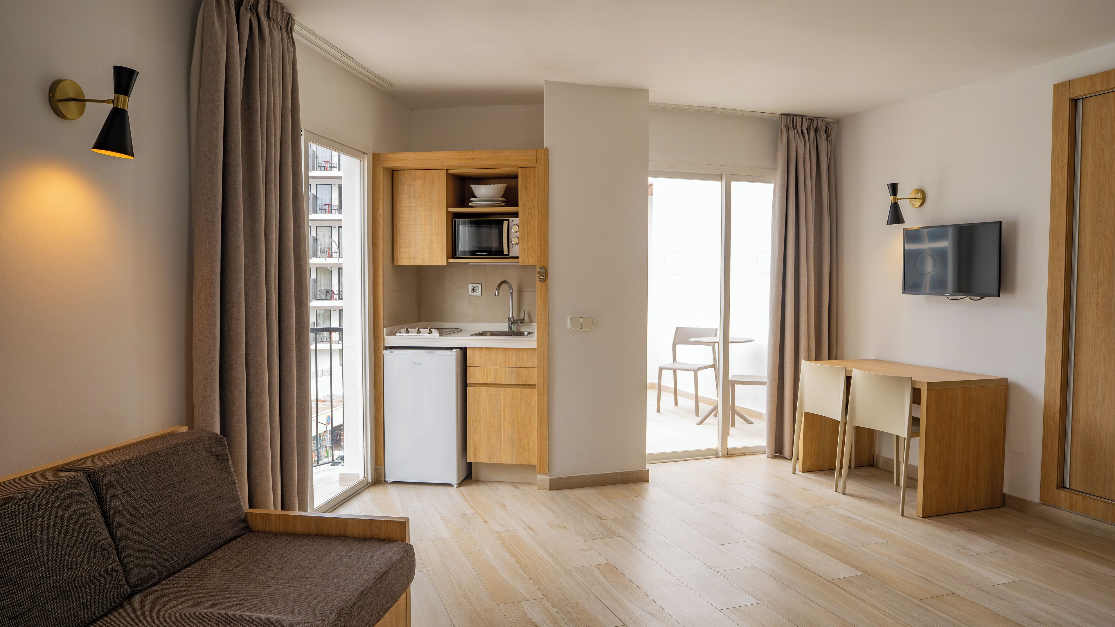 A modern apartment with a living area, kitchenette, and a dining space.