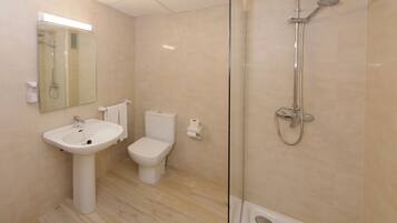 Een moderne badkamer met een douchecabine van glas, een wastafel op een voetstuk en een toilet.