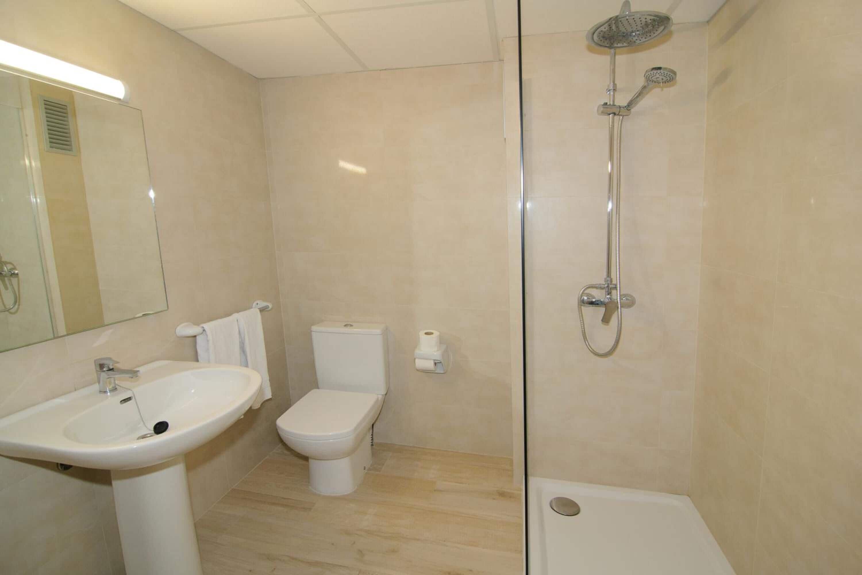 A bathroom with a sink, toilet, and shower.