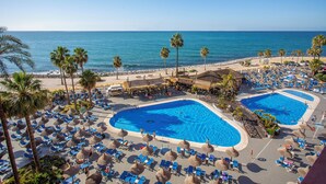 A resort with two large swimming pools, palm trees, and beach views. - Sunset Beach Club Hotel Apartments (Benalmádena)