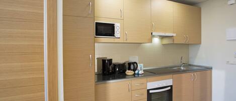A modern kitchen with wooden cabinets, a microwave, a coffee maker, and a dishwasher.