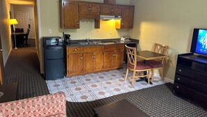 Un espacio habitable compacto con kitchenette, comedor y zona de estar.