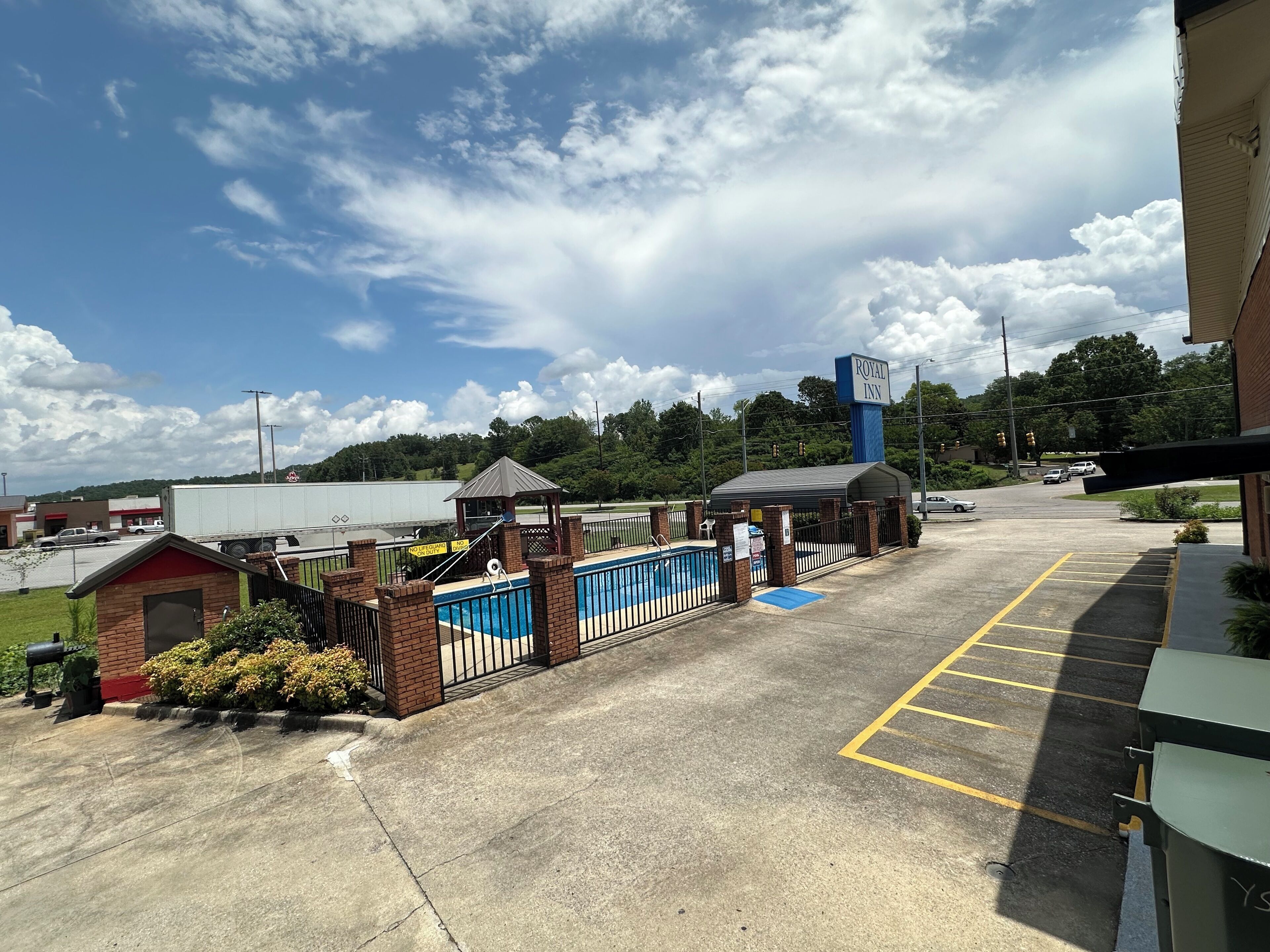 A parking lot with a pool area, a gazebo, and a sign for the Royal Inn.