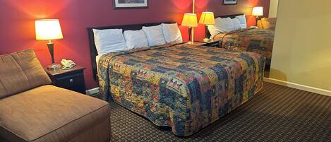 A hotel room with a bed, a chair, two bedside tables with lamps, and a large mirror.