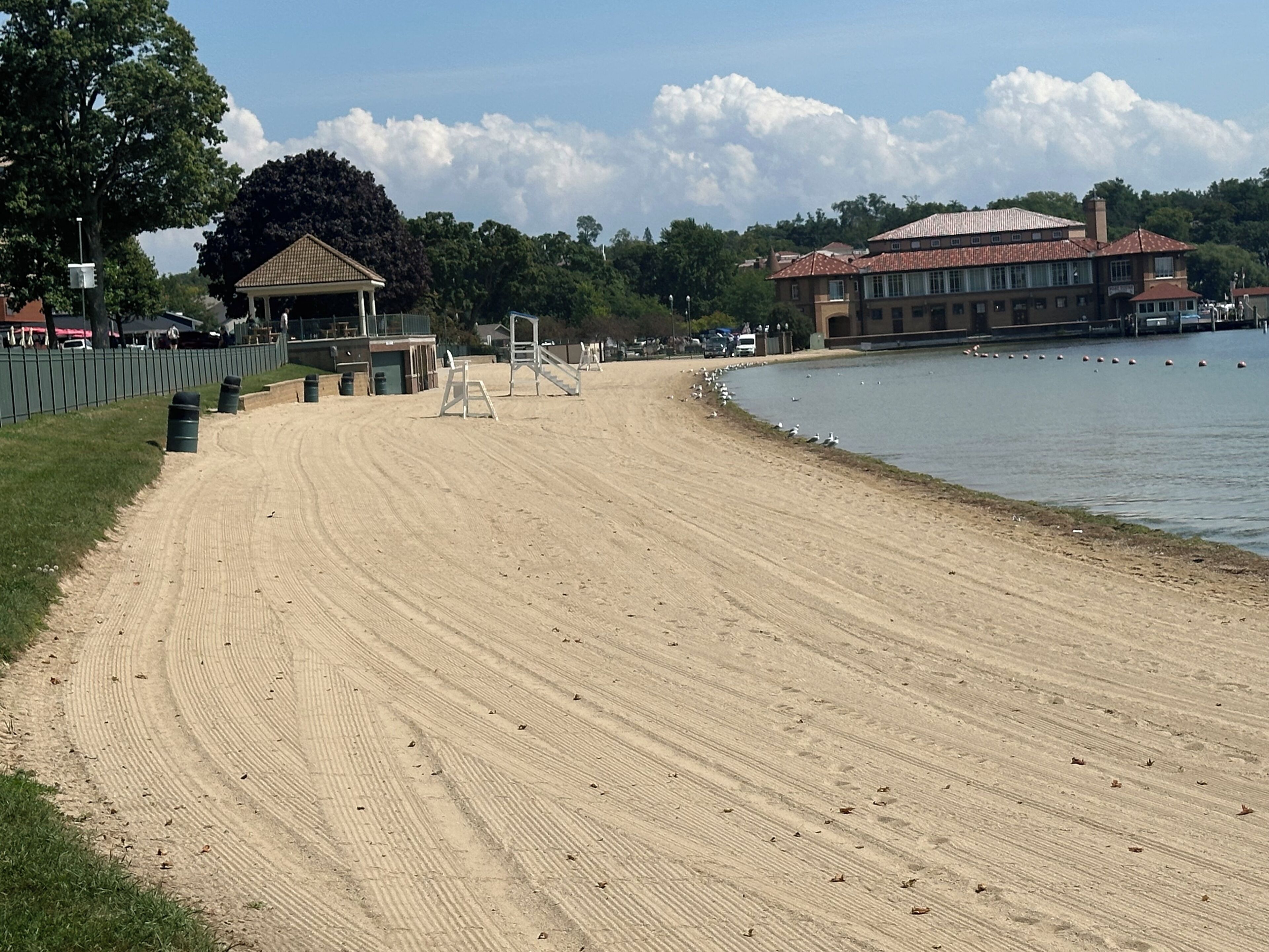 A sandy beach with a pavilion and a building in the background.