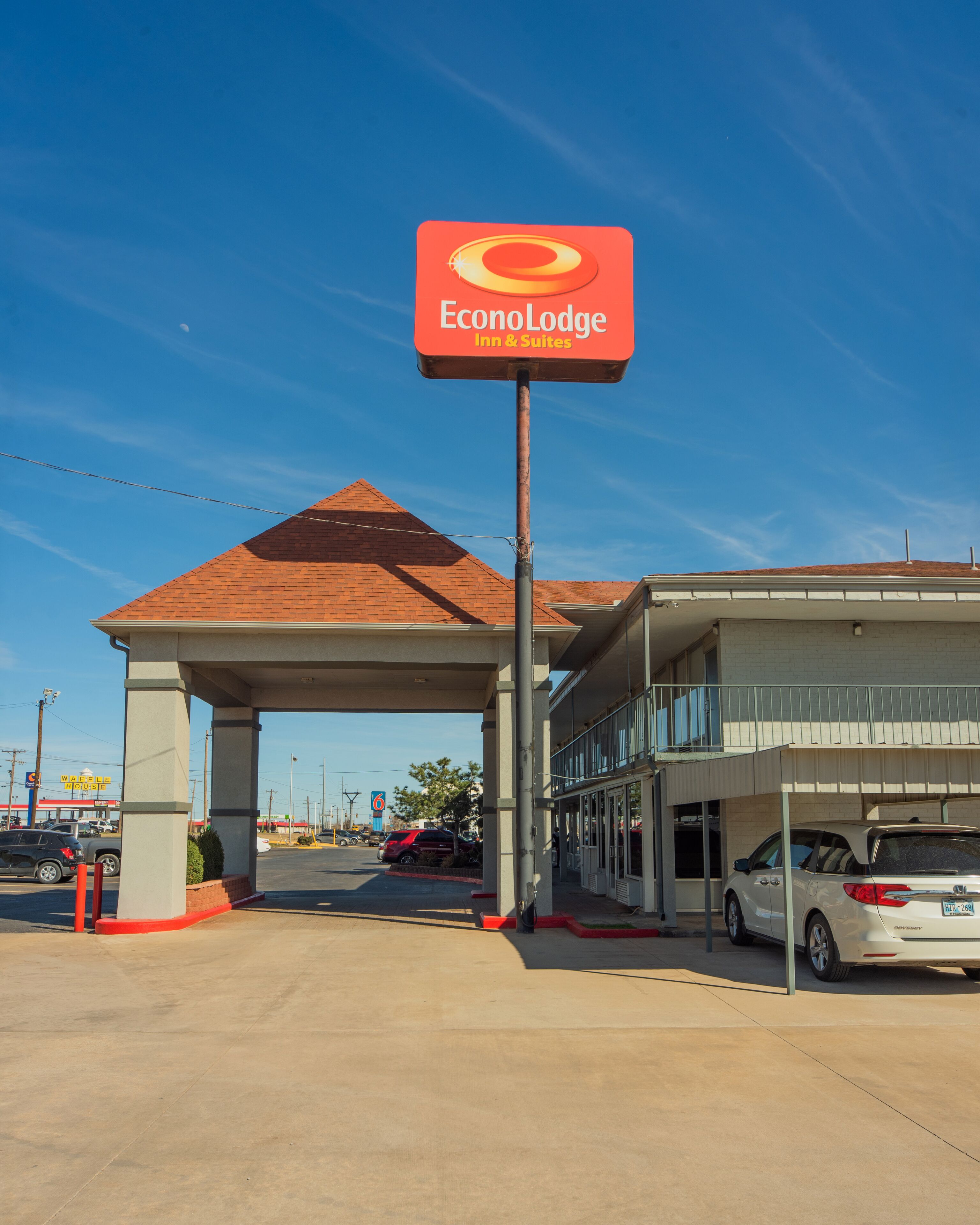 A hotel entrance with a red sign reading "Econolodge Inn & Suites".
