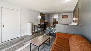 Un espacio habitable compacto con una cama, un escritorio pequeño, una silla y un sofá.