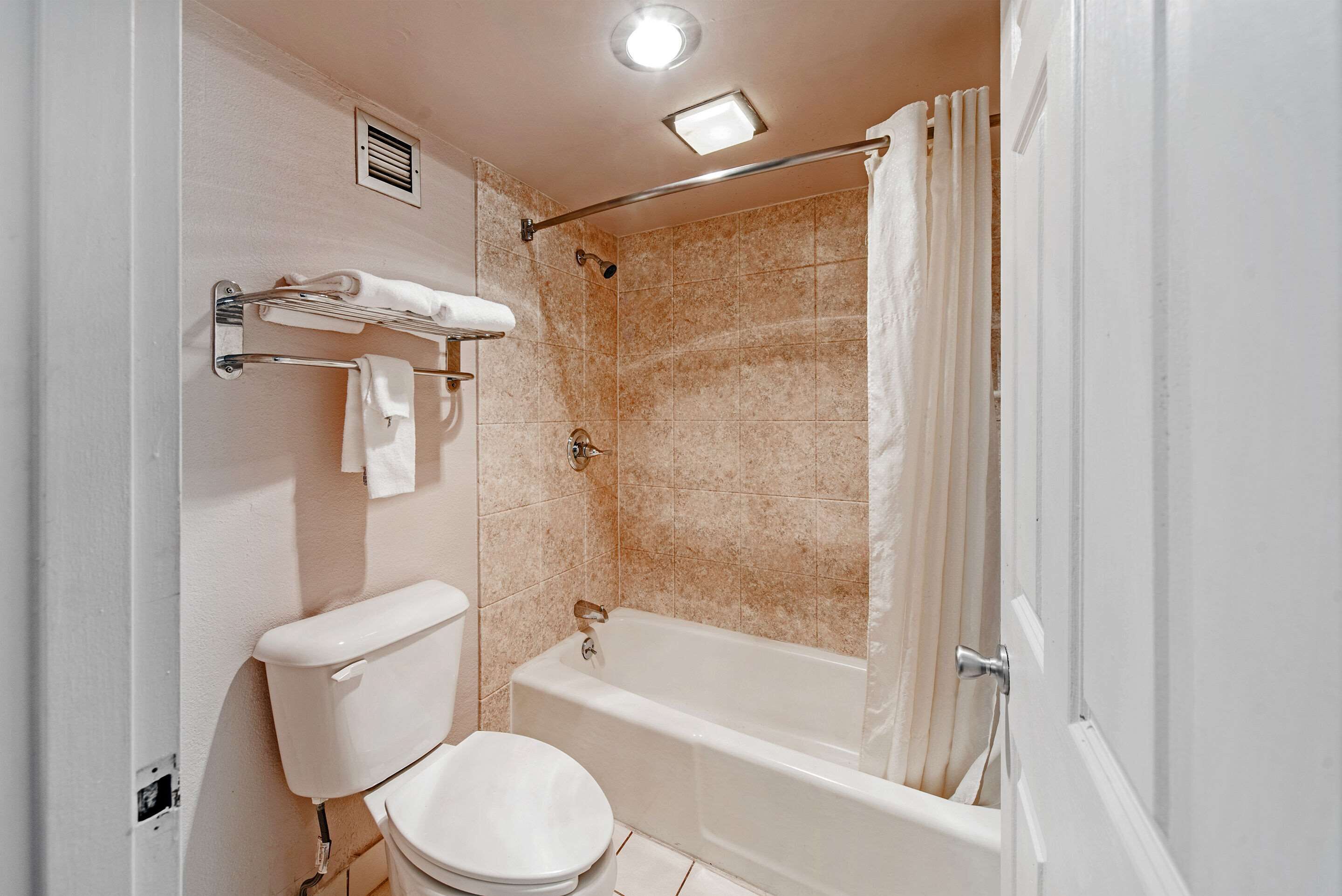 A bathroom with a toilet, a bathtub, and a shower curtain.