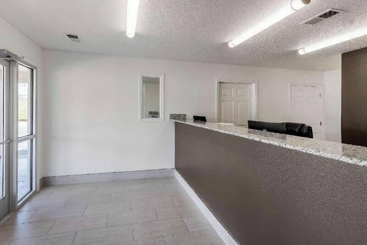 A clean, modern reception area with a counter, a door, and a window.