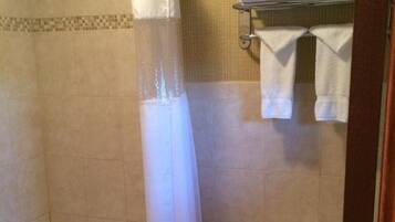 A bathroom with a bathtub, toilet, and a shower curtain.