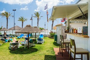 Een terras met lounge stoelen en een bar.