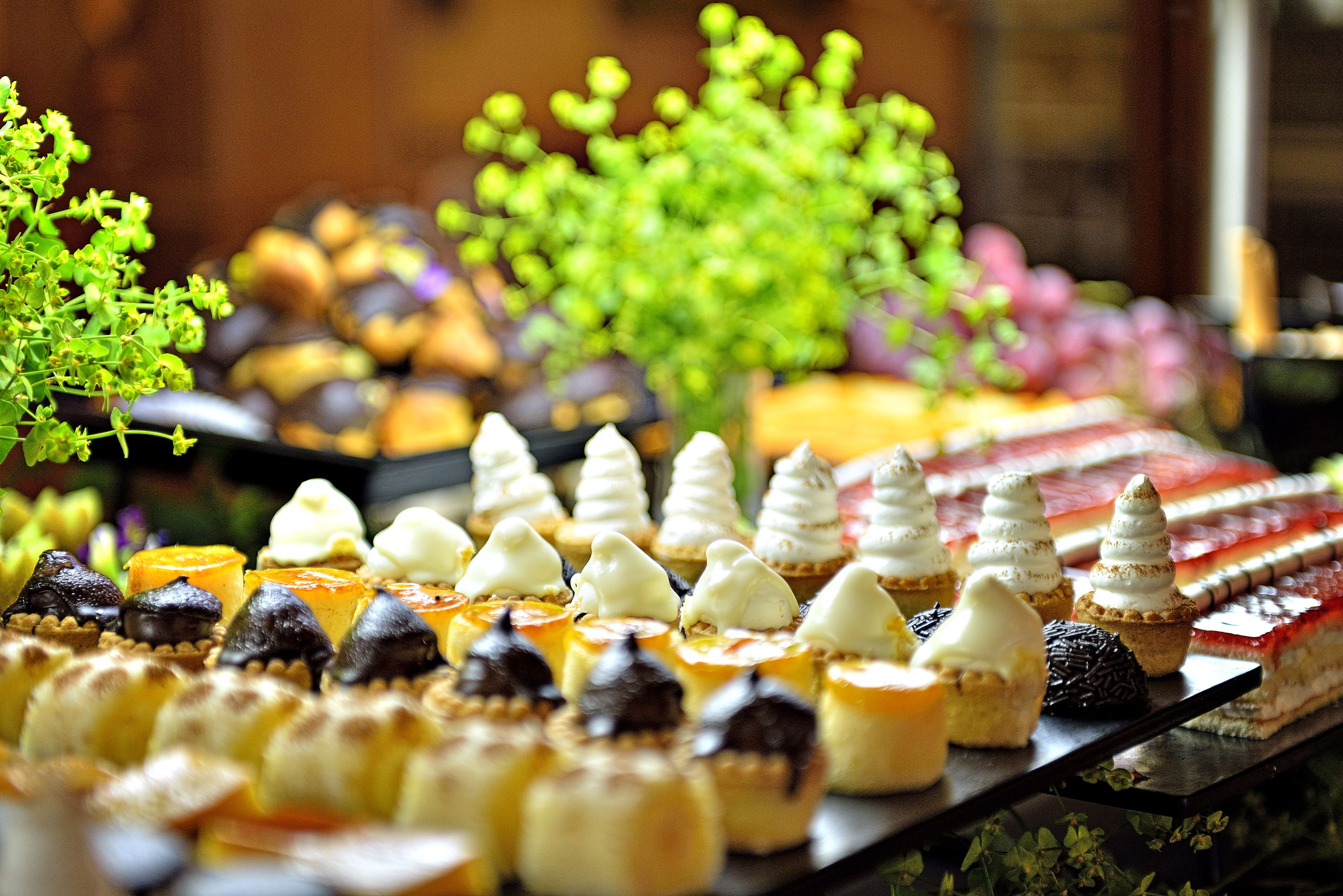 A variety of desserts on a tray, including cakes and pastries with different toppings and decorations.