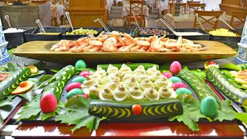 A buffet with various food items including shrimp, olives, and a variety of fruits and vegetables.