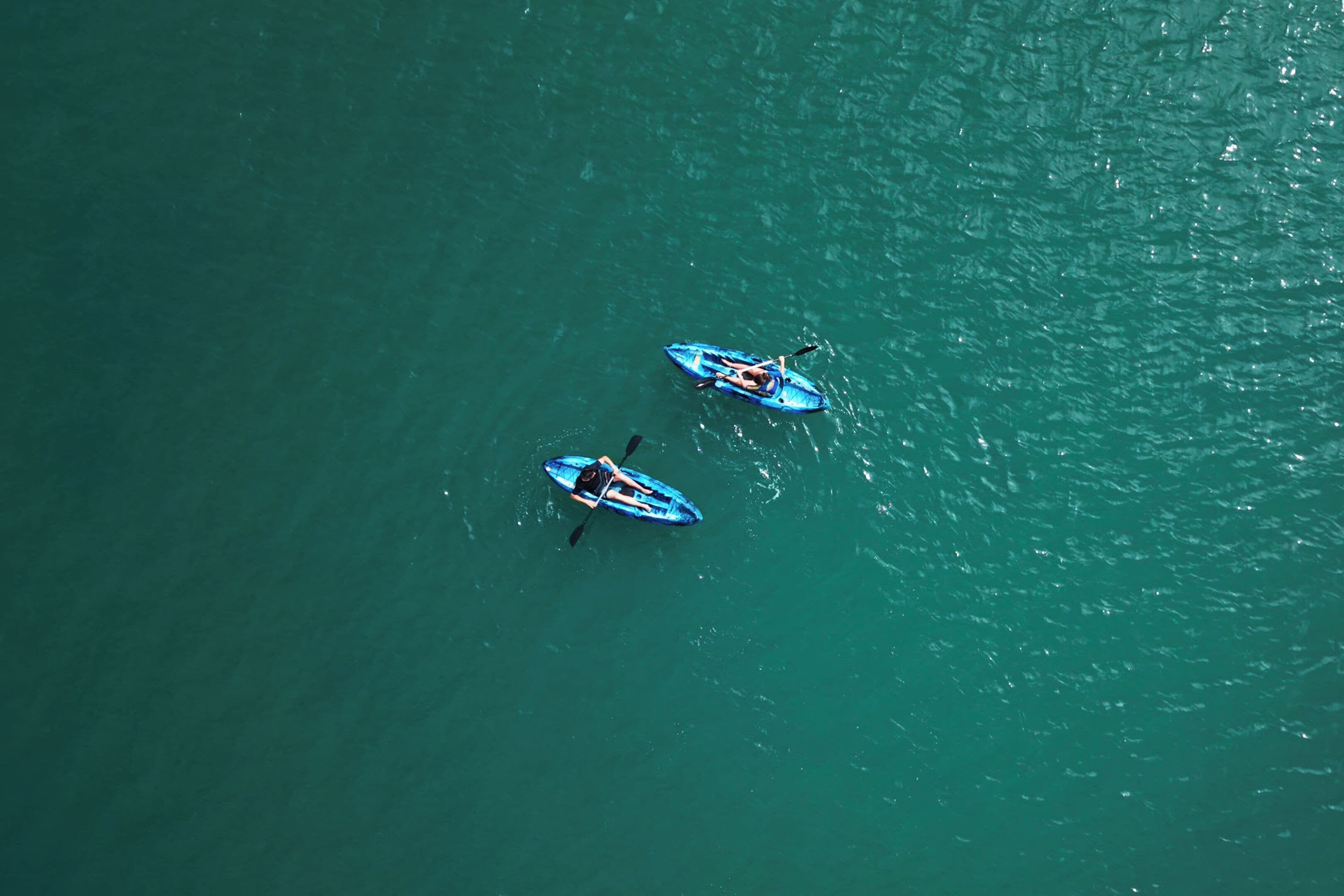 Two kayaks on a calm body of water.
