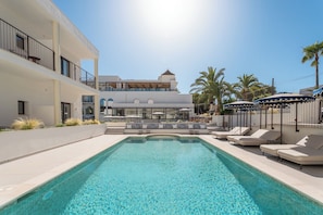Una piscina al aire libre de temporada, sombrillas