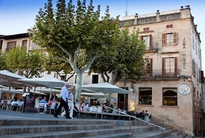 A building with a sign reading "JUMA HOTEL" and a restaurant sign "CR 21". - Hotel Juma (Pollenca)