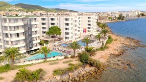 A coastal hotel with multiple balconies, a swimming pool, and a beachside view. - Apartamentos Vibra Jabeque Soul (Ibiza Town)