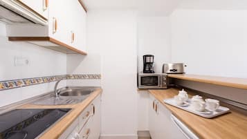 Fridge, microwave, coffee/tea maker, cookware/dishes/utensils