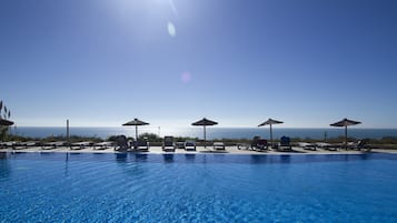 Piscine couverte, piscine extérieure, parasols de plage, chaises longues