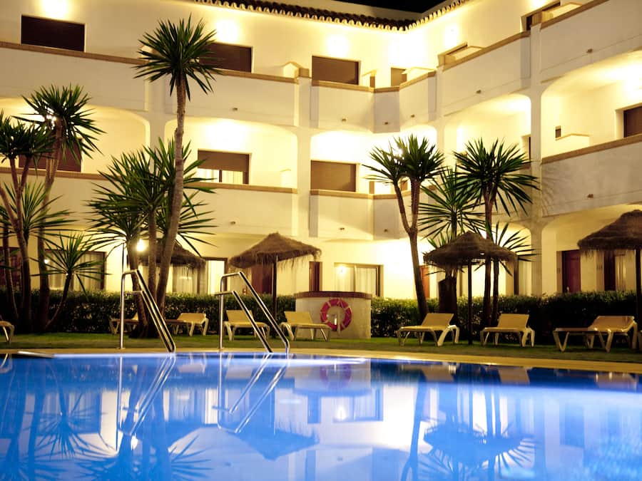 Een buitenzwembad, parasols bij het zwembad en ligstoelen