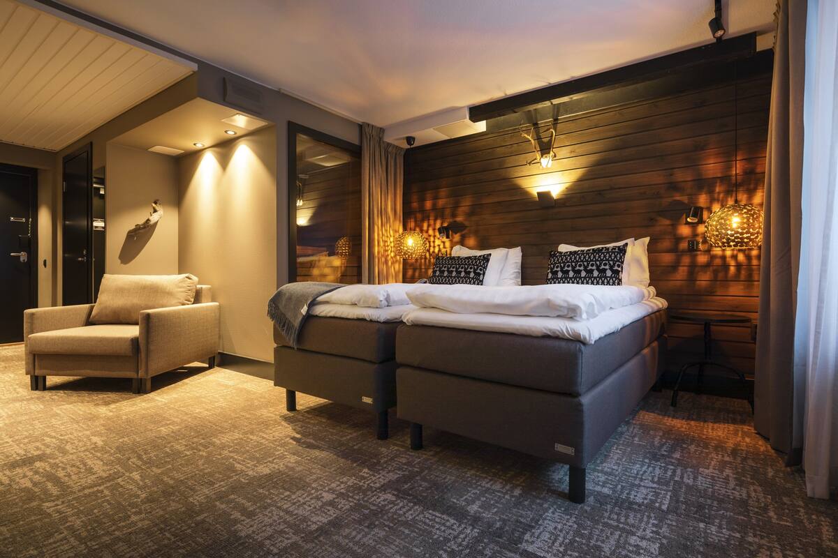 Un dormitorio moderno con una cama grande, una silla y un escritorio.