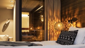 Ein modernes Hotelzimmer mit einem Bett, einer Wanddekoration und einer außergewöhnlichen, strukturierten Leuchte.