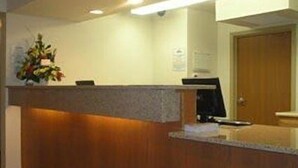 A reception desk with a wooden counter and a small plant on top.