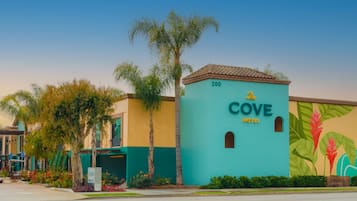 A hotel named 'Cove Hotel' with a teal facade, numbered '200', and a mural of tropical plants.