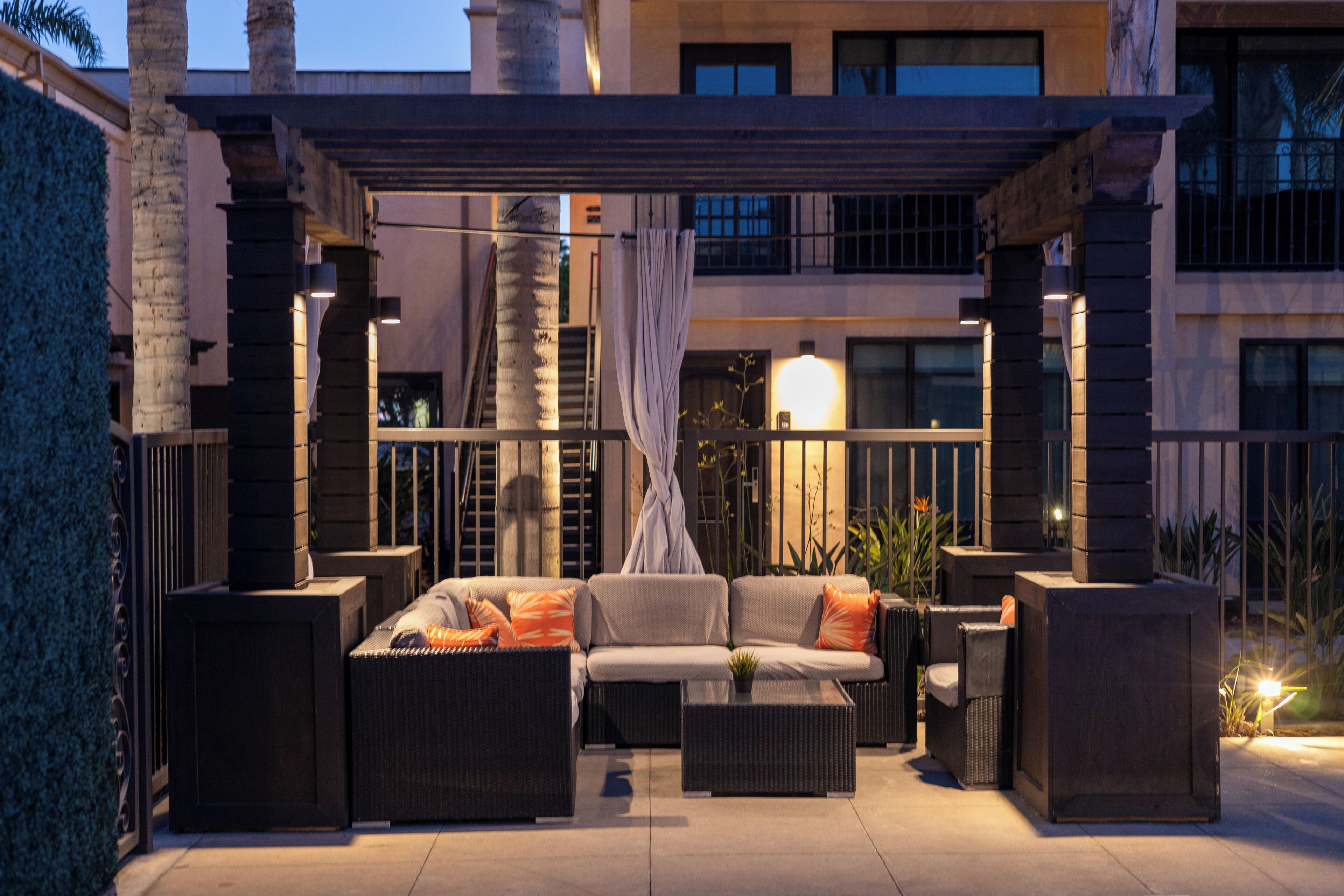 An outdoor patio area with a sofa set, a coffee table, and a lamp.