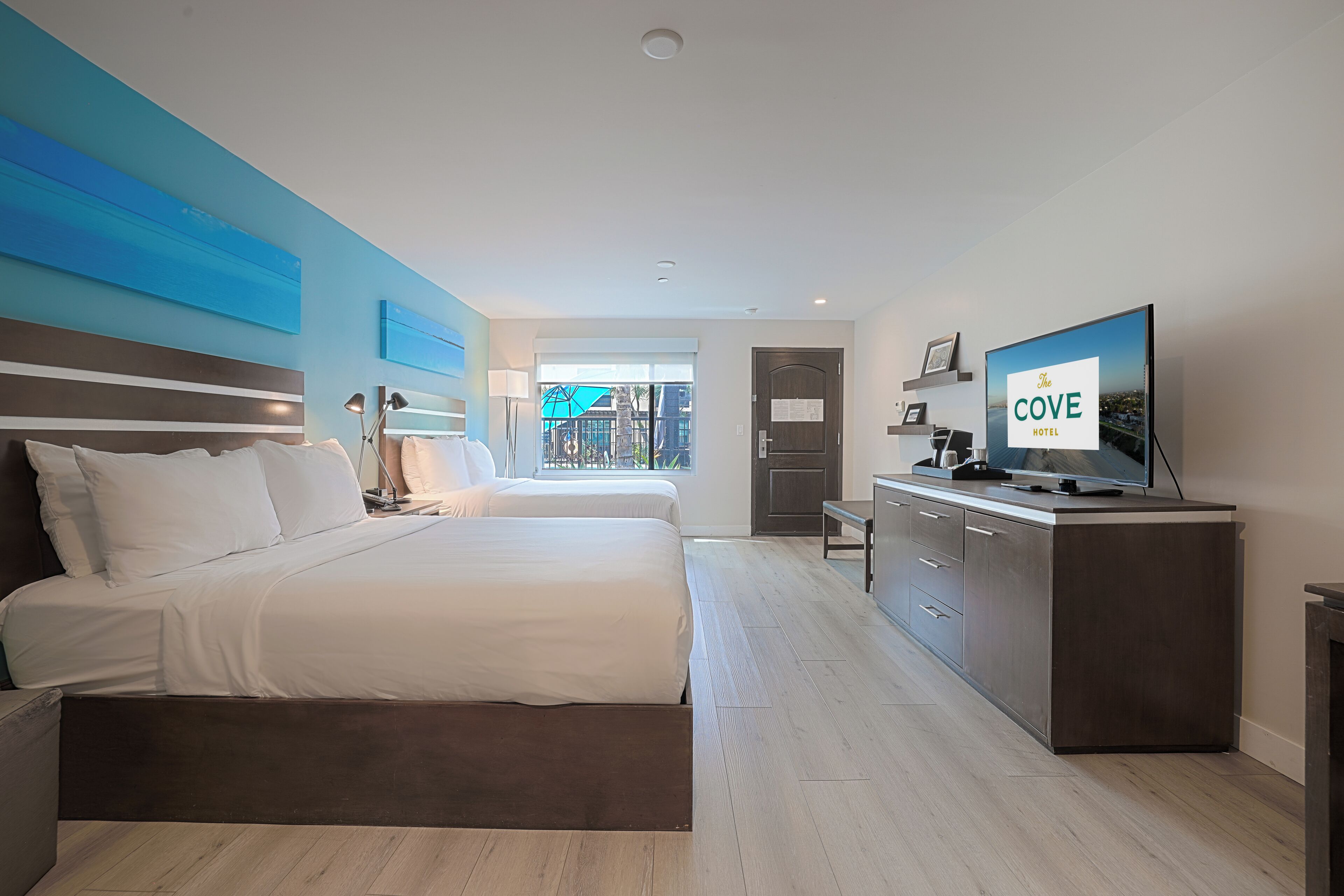Una habitación de hotel moderna con una cama grande, televisión y vistas a la ciudad.