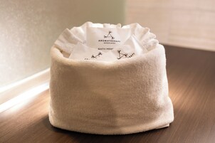 A white, textured bath mat with a label reading 'Aromatherapy Associates Bath Mine.'