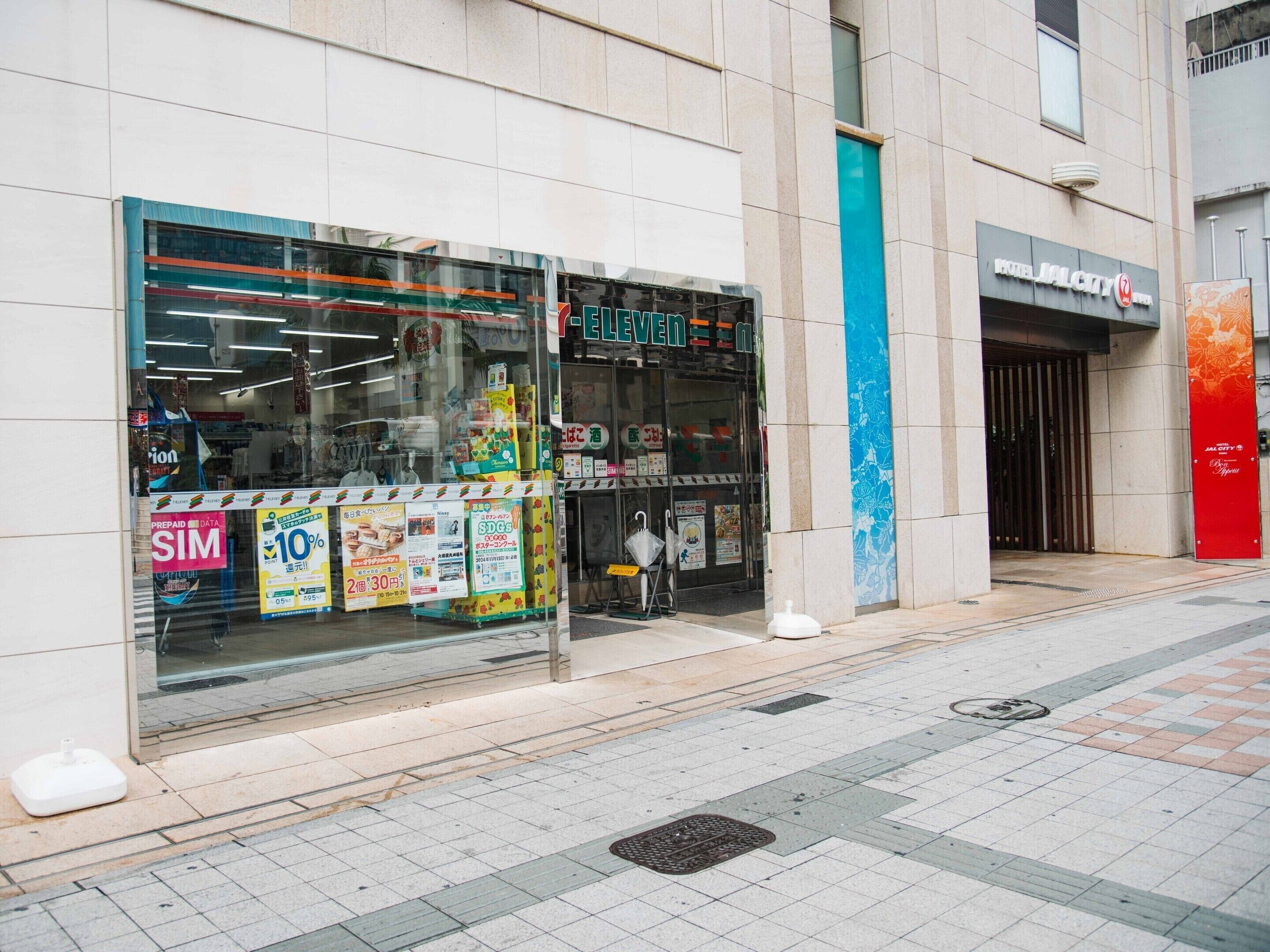 A storefront with large glass windows displaying various advertisements and promotions.