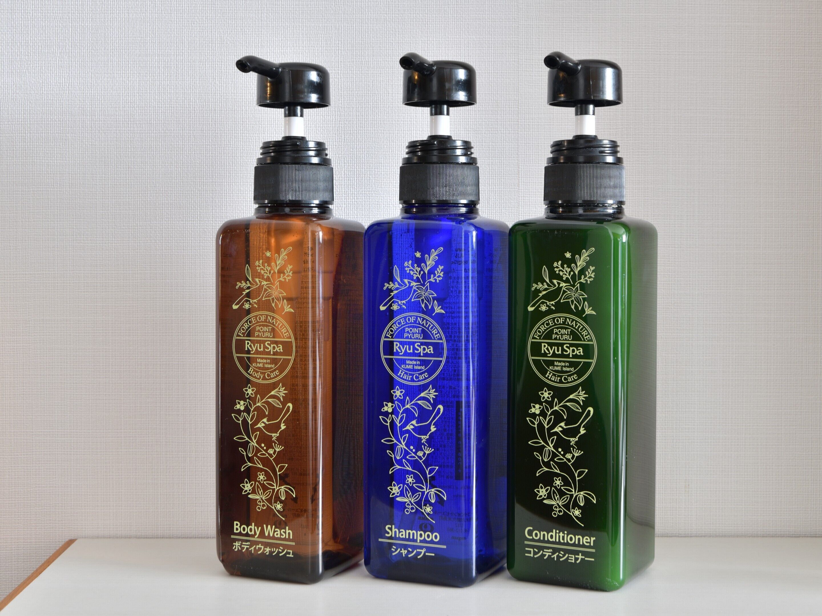Trois flacons de produits de soins corporels de la gamme Ryu Spa.