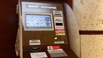 Un distributeur automatique intelligent doté d’un écran numérique, de boutons de sélection des devises et d’un lecteur de cartes.