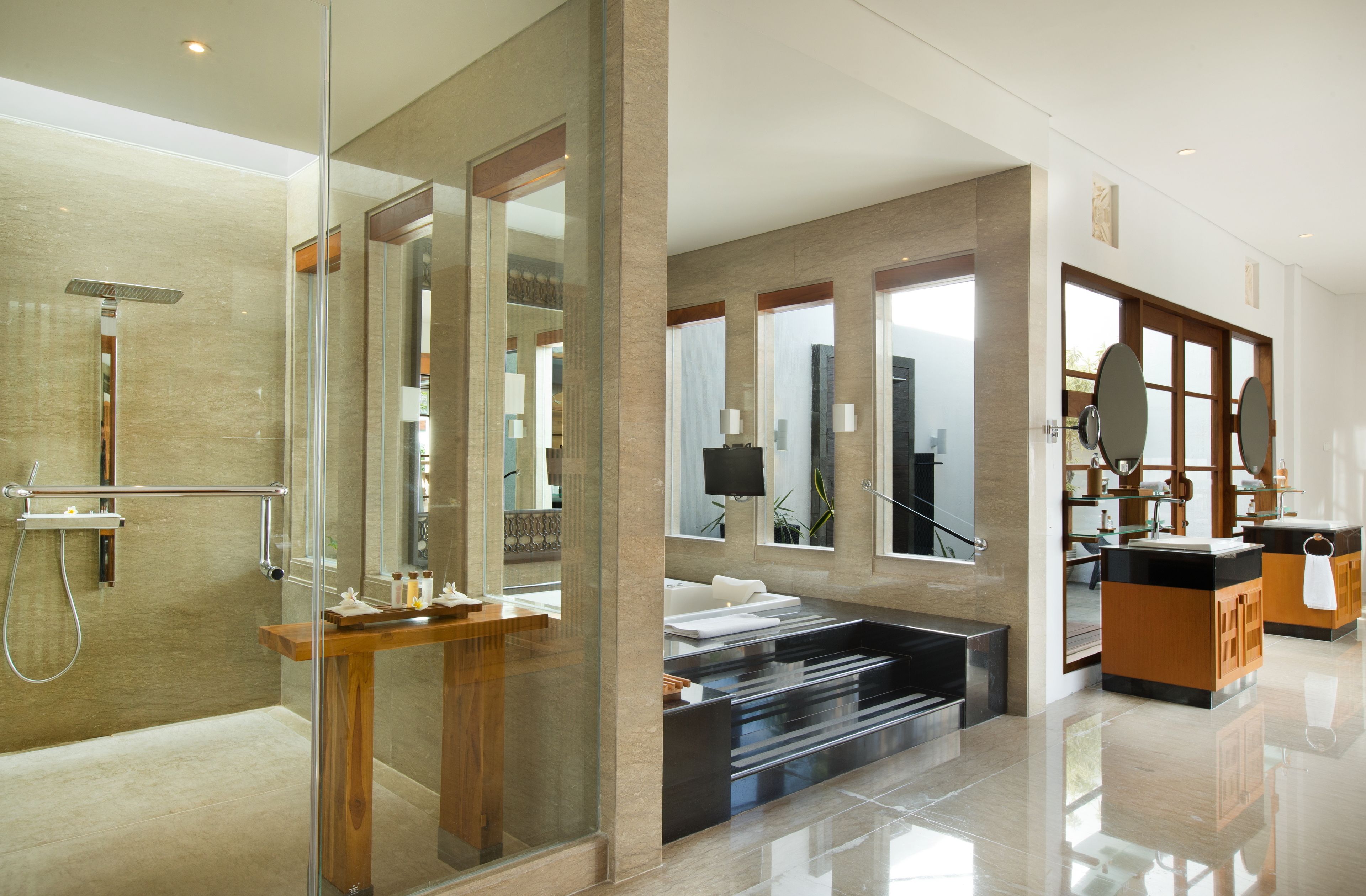 A modern bathroom with a glass-enclosed shower, a wooden vanity, and a large mirror.