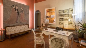 A cozy room with a sofa, a dining table, chairs, a bookshelf, and framed pictures on the wall. - Home in Florence (Florence)