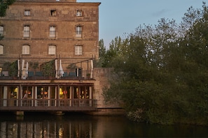 A historic building with a balcony overlooking a river. - Hacienda Zorita Wine Hotel - Small Luxury Hotels (Valverdon)