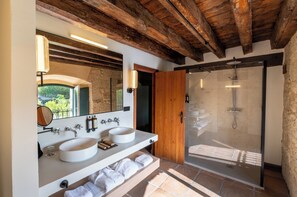 Une salle de bain avec deux lavabos, un miroir et une douche.