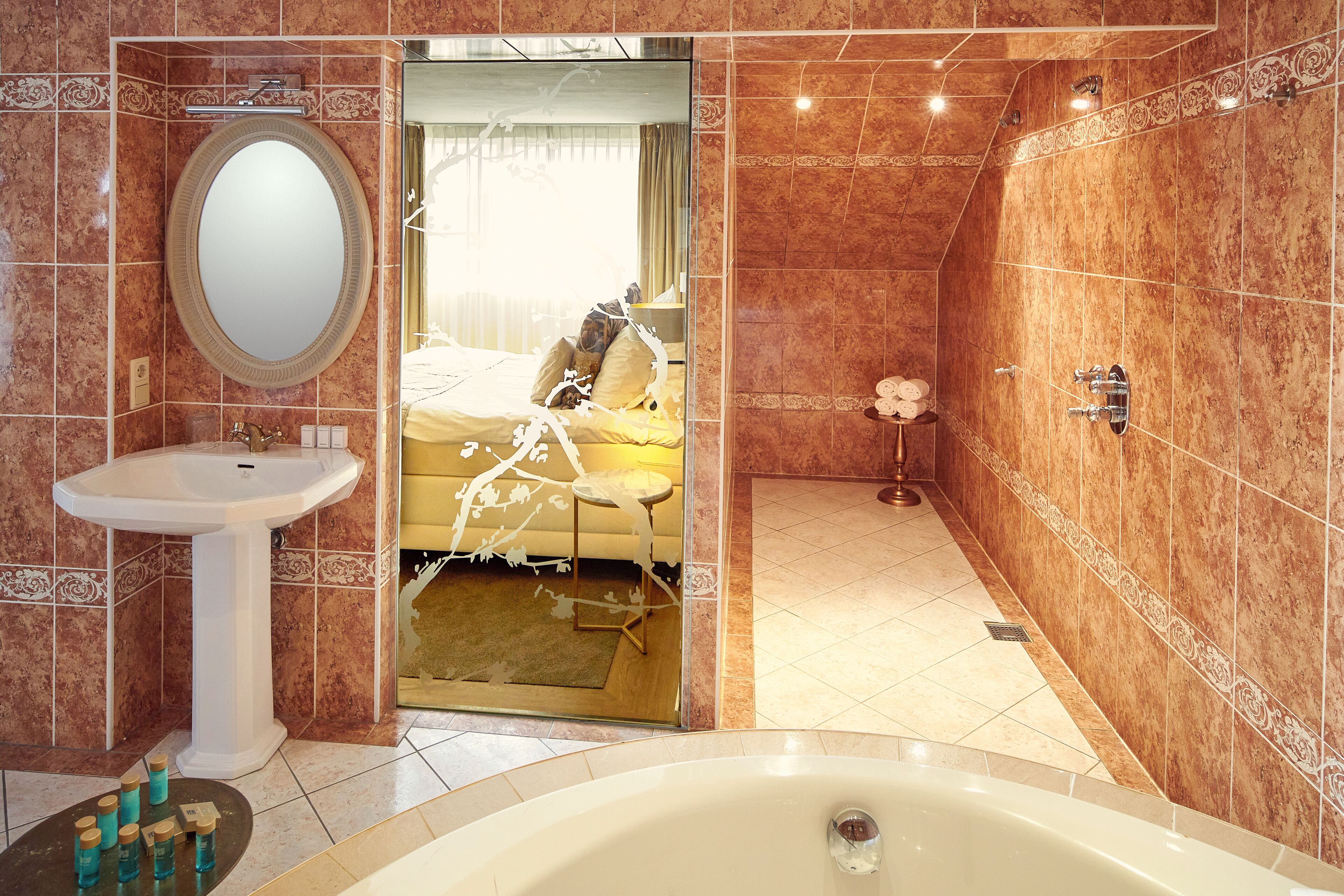 Un baño con lavamanos, espejo y bañera.