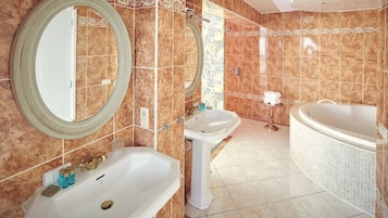 Un baño con una bañera grande, dos lavamanos y tres espejos.