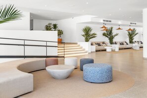 A modern lobby with a curved seating area, a staircase, and potted plants. - Hotel HSM Atlantic Park Hotel (Calvia)