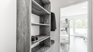 Una habitación moderna con una estantería de madera, camas literas y vistas al exterior.