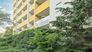 Un hotel de diseño moderno, con balcones y un cartel que indica que se encuentra ubicado en el Estadio Olímpico.