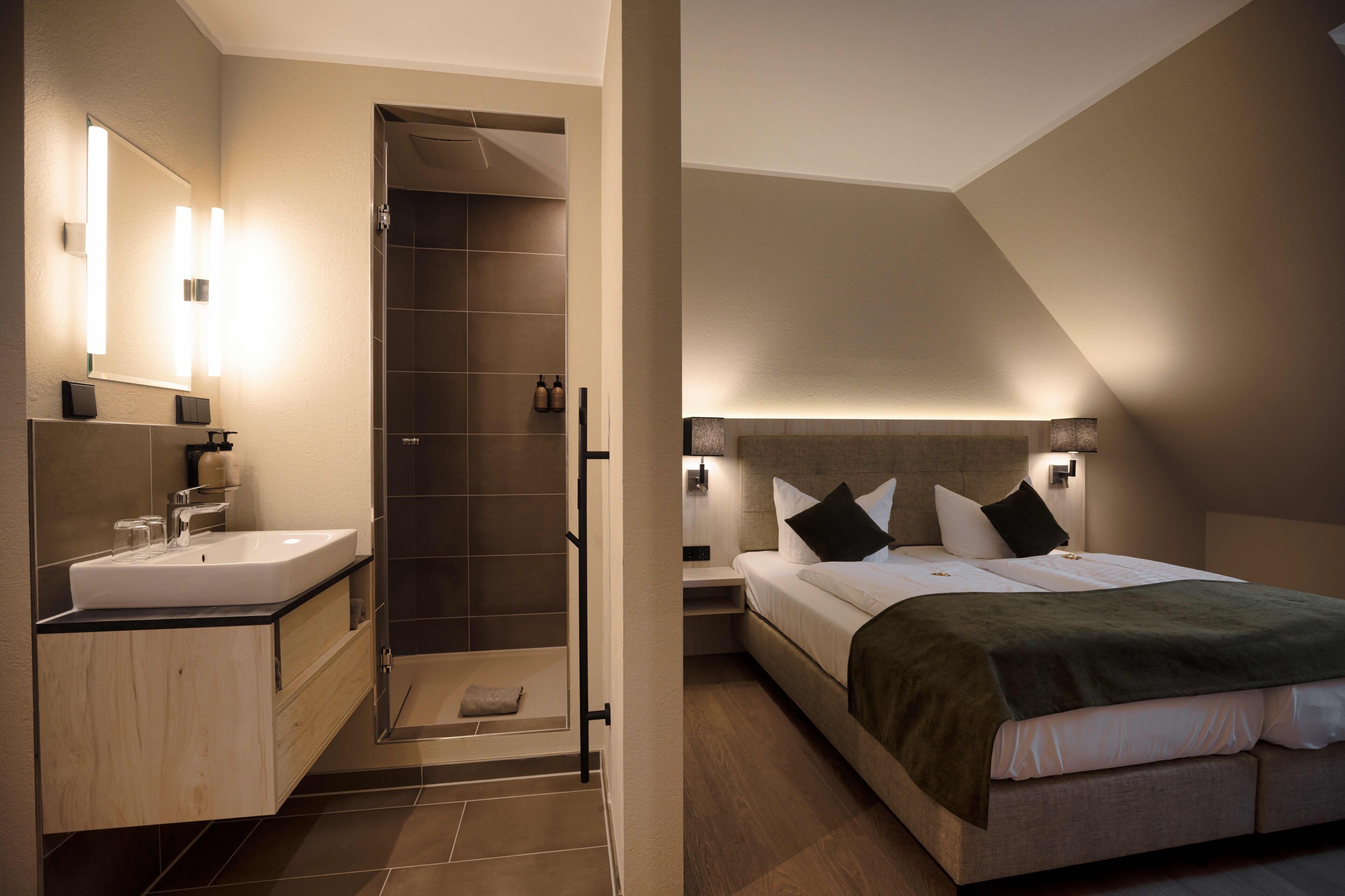 Ein modernes Schlafzimmer mit Bett, Nachttischen und einer Duschkabine.